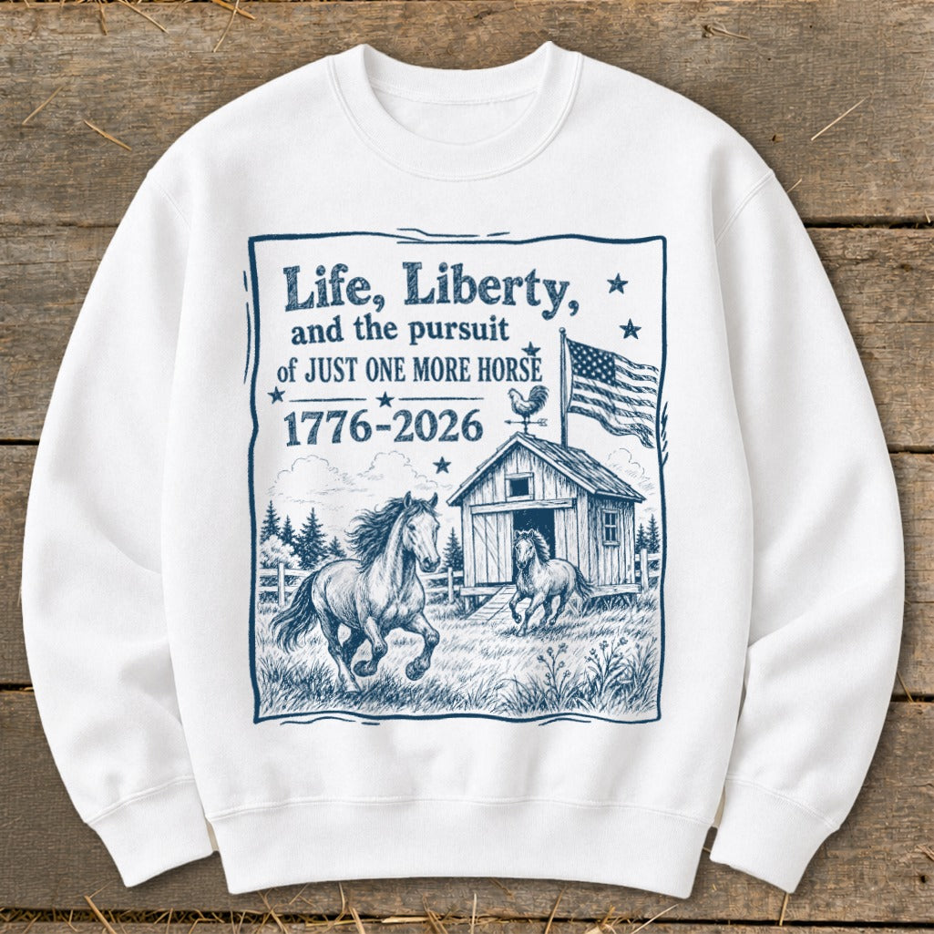 White sweatshirt with "Life, Liberty, and the pursuit of JUST ONE MORE HORSE 1776-2026" graphic.