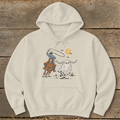 Skeleton cowboy on horseback lassoing a ghost steer under a harvest moon.