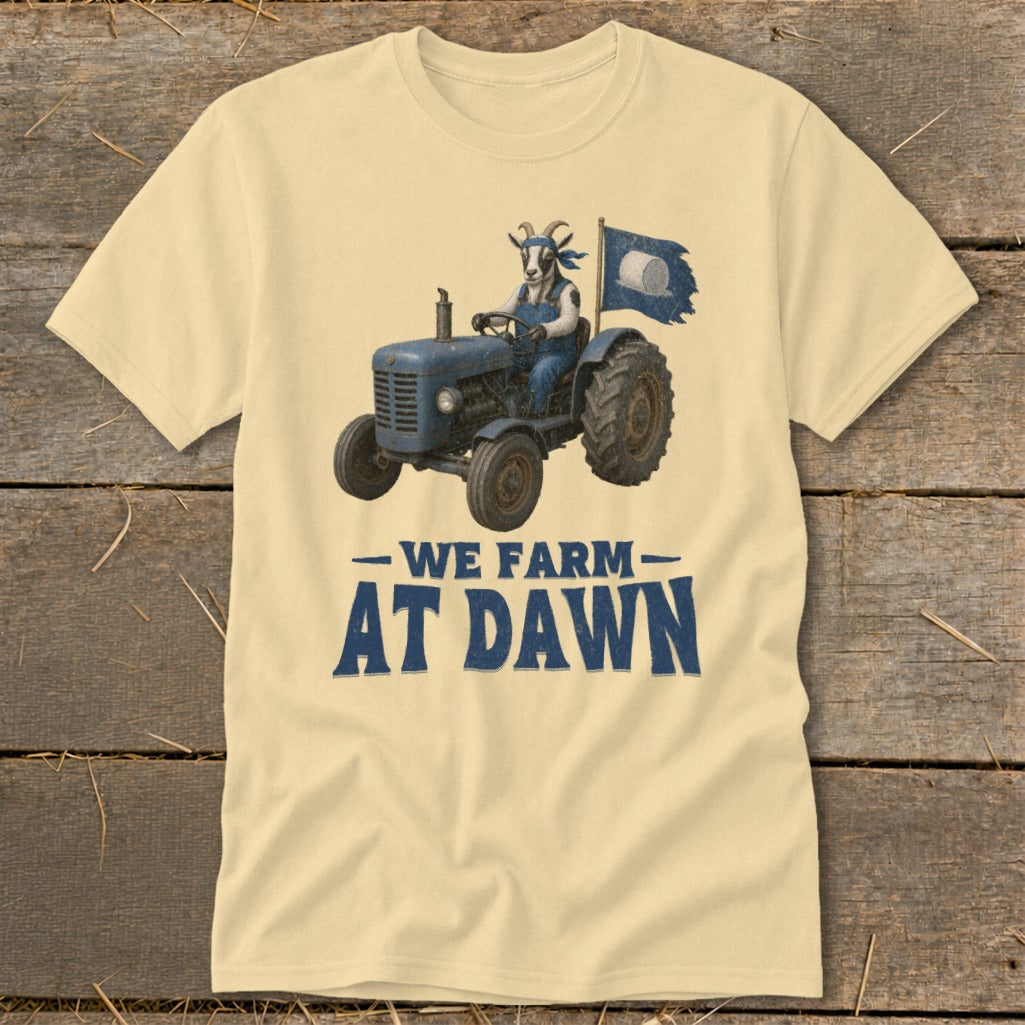 Goat wearing overalls driving a tractor with flag and text "We Farm At Dawn."