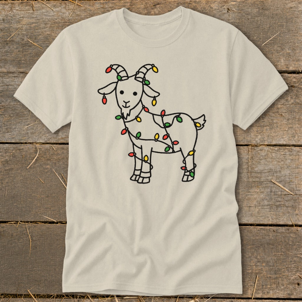 Light beige t-shirt featuring a black line drawing of a goat wrapped in colorful Christmas lights.