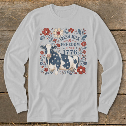 Long sleeve shirt with a patriotic cow and floral design, saying "Fresh Milk & Freedom Since 1776".