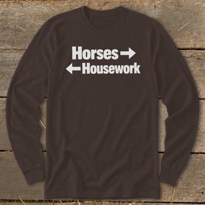 A dark brown long-sleeve t-shirt with white text reading Horses with a right arrow and Housework with a left arrow.