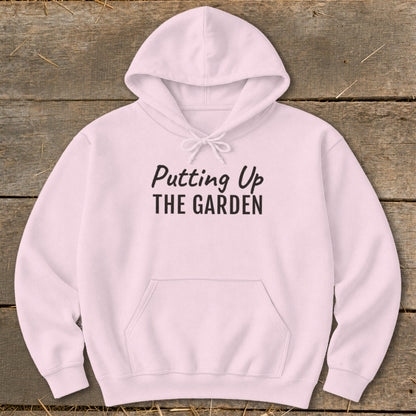 Pink hoodie with "Putting Up THE GARDEN" text in black lettering.