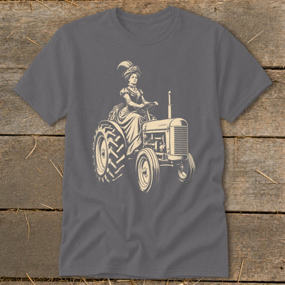 Woman in vintage dress and hat driving a tractor, graphic print on gray t-shirt.