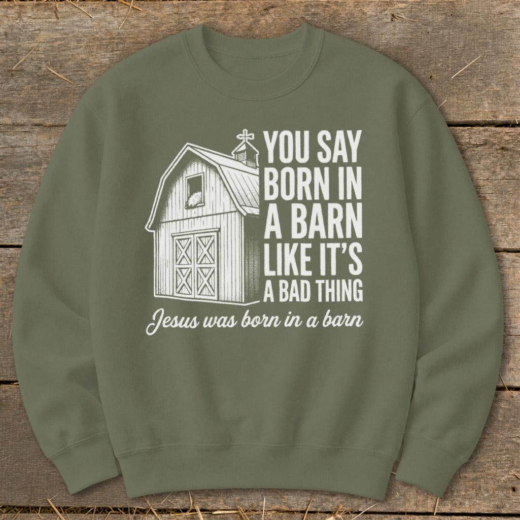 Olive green sweatshirt with white graphic of a barn and text about Jesus being born in a barn.