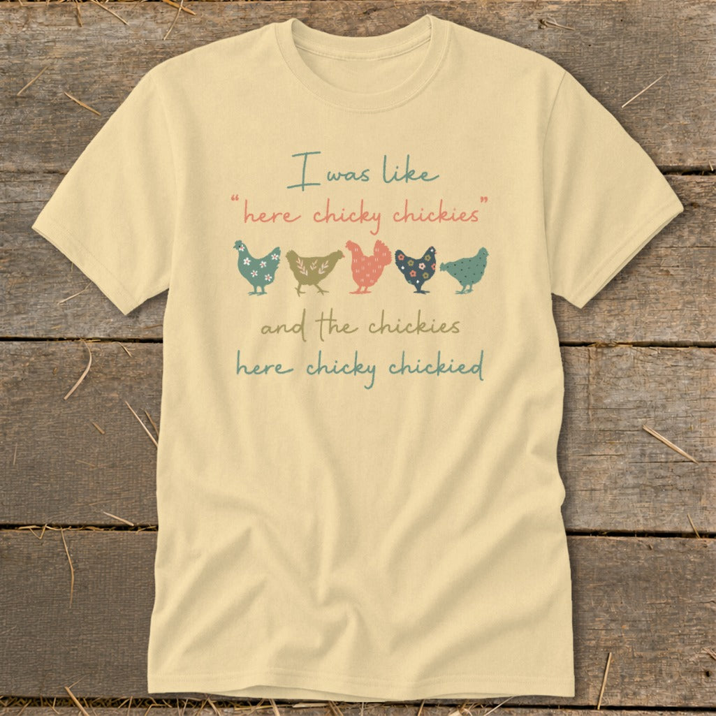 Light yellow t-shirt with "I was like 'here chicky chickies' and the chickies here chicky chickied" text and chickens.
