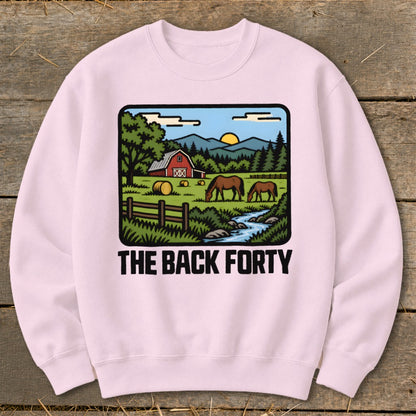 Light pink crewneck sweatshirt featuring a cartoon farm scene graphic with horses, a red barn, and the text The Back Forty.
