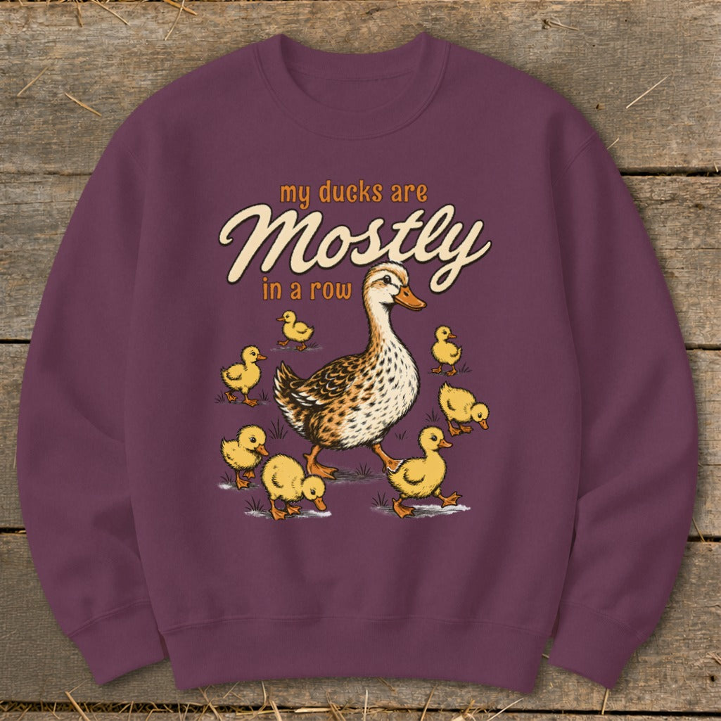 Duck with ducklings on maroon sweatshirt, text "my ducks are Mostly in a row".