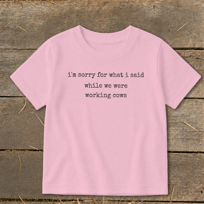 Pink t-shirt with black text reading "i'm sorry for what i said while we were working cows".