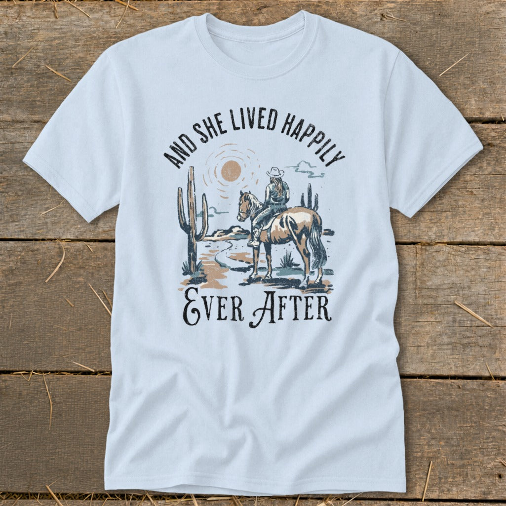 White t-shirt with desert graphic and text "And She Lived Happily Ever After."