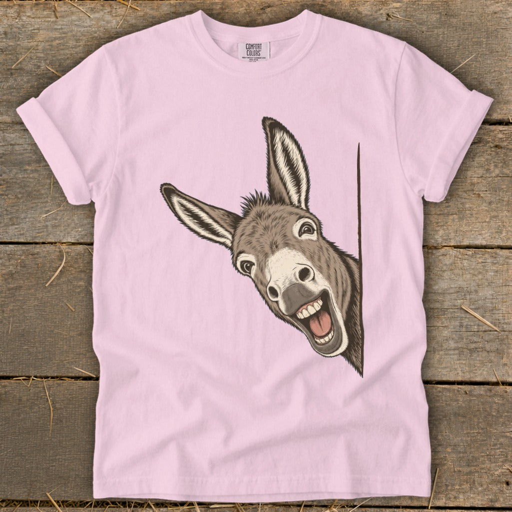Pink t-shirt with a cartoon donkey peeking from the side, looking excited.
