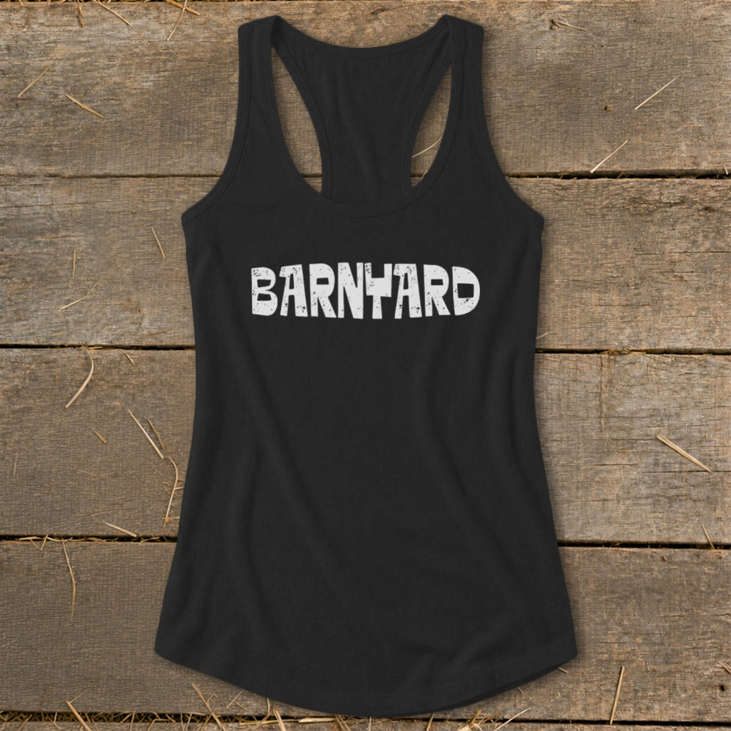 Black racerback tank top with distressed white Barnyard text on a rustic wooden background.