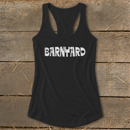 Black racerback tank top with distressed white Barnyard text on a rustic wooden background.