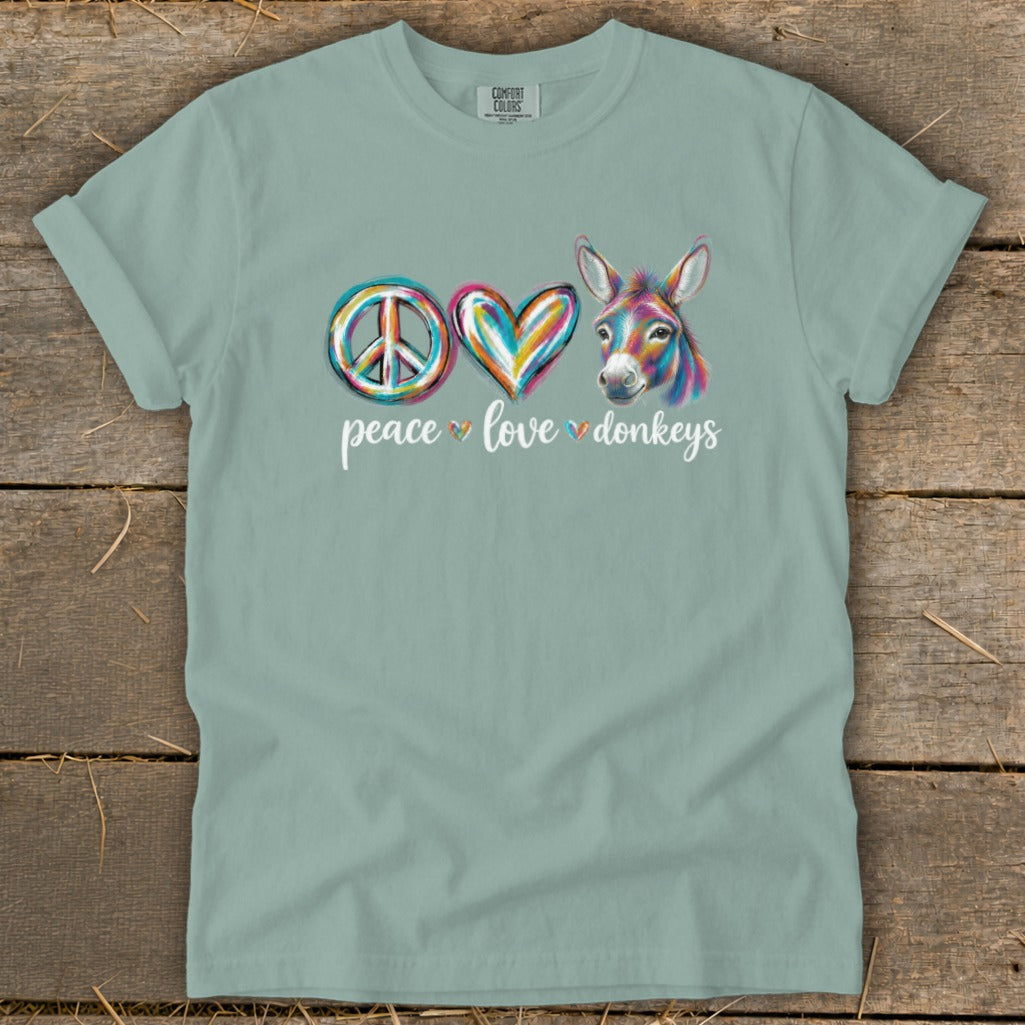 Green t-shirt with peace, heart, and donkey graphic and "peace love donkeys" text.