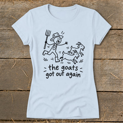 Light blue t-shirt with a cartoon of a farmer chasing goats and text "the goats got out again".