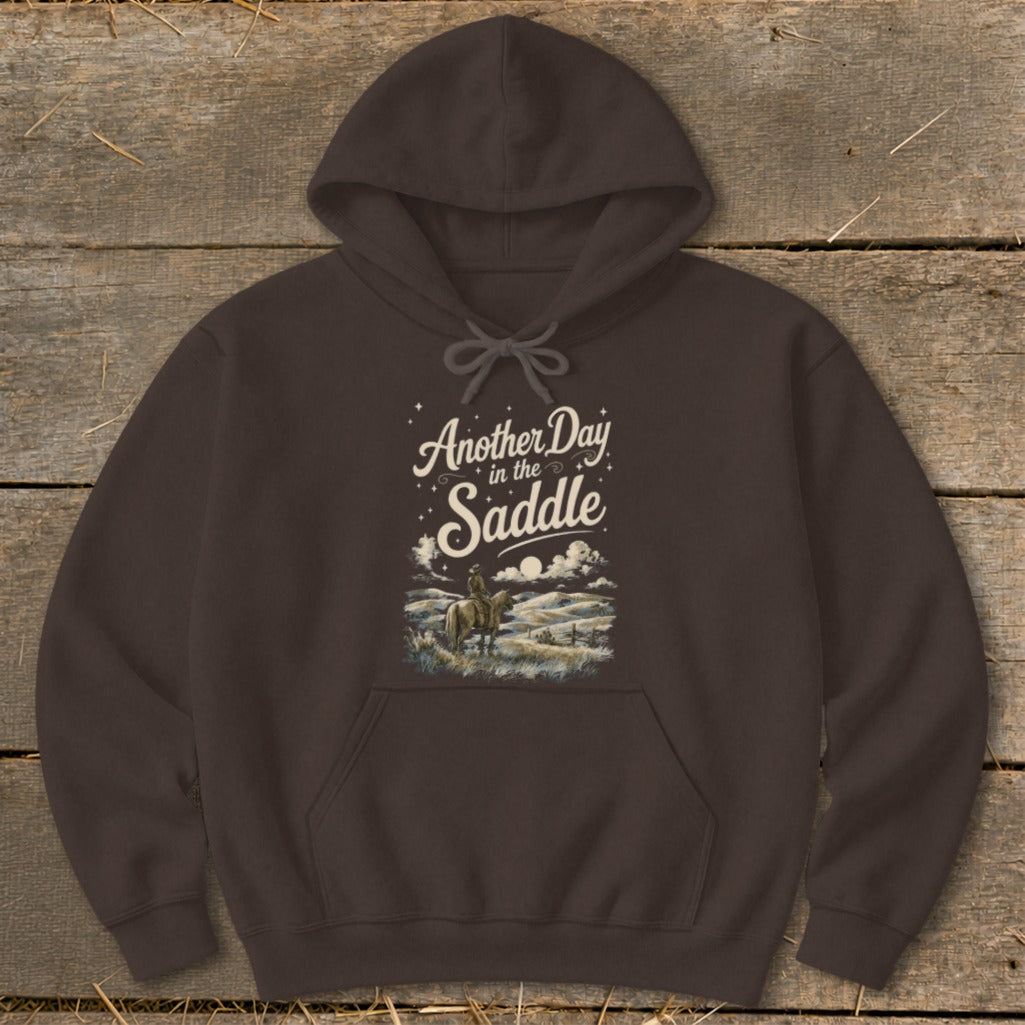 Brown hoodie with graphic "Another Day in the Saddle" and cowboy on horse.