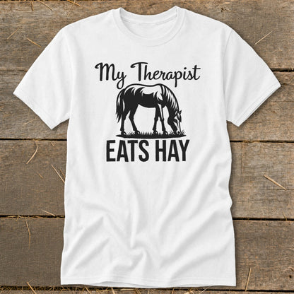 White t-shirt with graphic: "My Therapist EATS HAY" and horse silhouette.