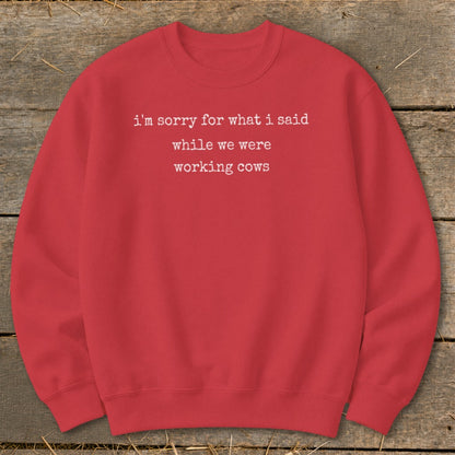 Red sweatshirt with white text "i'm sorry for what i said while we were working cows".