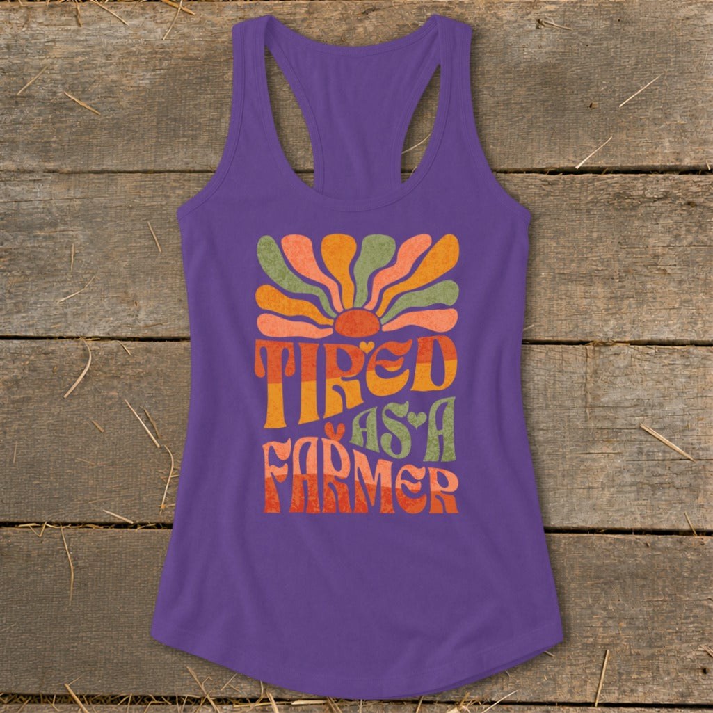 Purple tank top with "Tired As A Farmer" text and sun graphic.