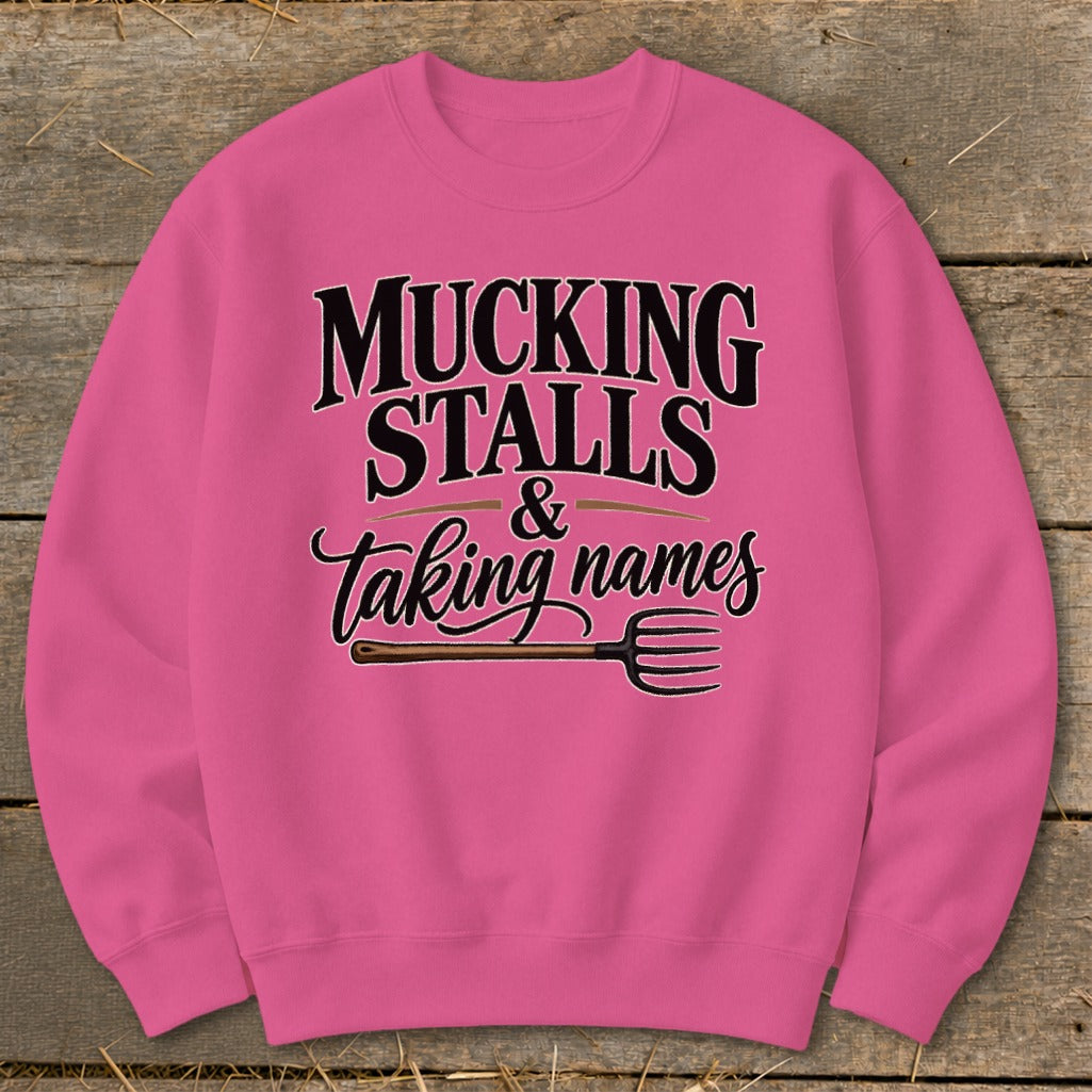 Pink sweatshirt with "Mucking Stalls & Taking Names" text and pitchfork graphic.