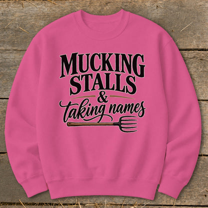 Pink sweatshirt with "Mucking Stalls & Taking Names" text and pitchfork graphic.
