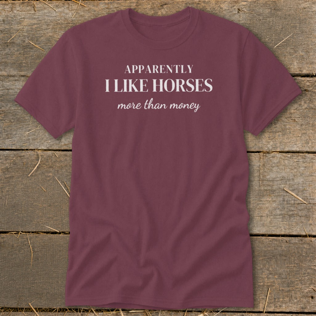 Maroon t-shirt with white text that reads "APPARENTLY I LIKE HORSES more than money".