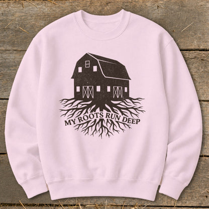 Pink sweatshirt with a graphic of a barn with roots and text "MY ROOTS RUN DEEP".