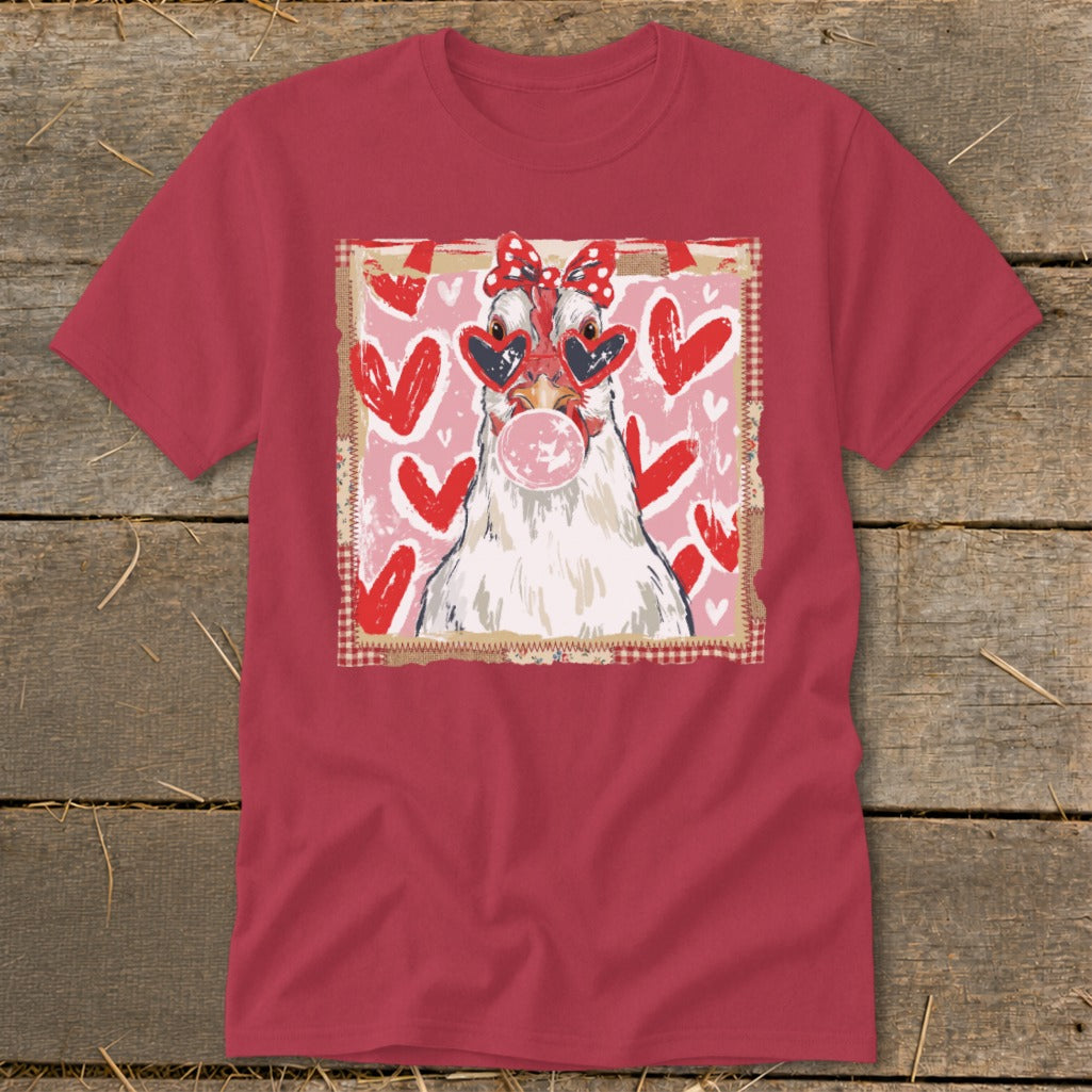 Chicken wearing heart sunglasses and red bow blows pink bubblegum, surrounded by hearts.