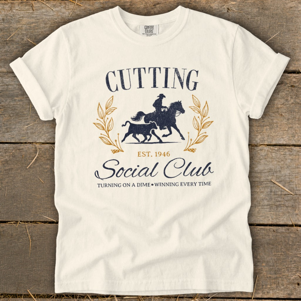 T-shirt with navy graphic of a cowboy on horseback and a bull, "Cutting Social Club" text.