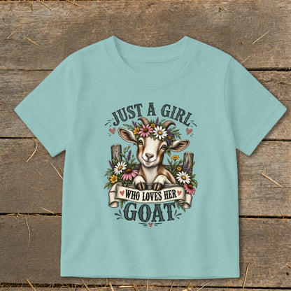 A goat wearing a flower crown on a teal t-shirt with "Just a girl who loves her goat" text.