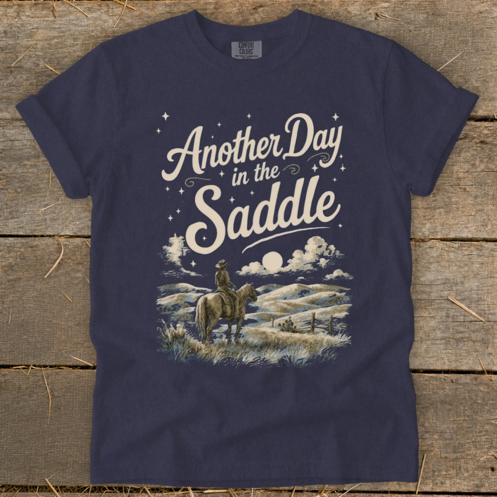 Dark navy CMFORT COLORS t-shirt with "Another Day in the Saddle" graphic.