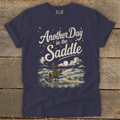 Dark navy CMFORT COLORS t-shirt with "Another Day in the Saddle" graphic.
