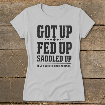 Light gray t-shirt with black text reading "GOT UP FED UP SADDLED UP JUST ANOTHER BARN MORNING".