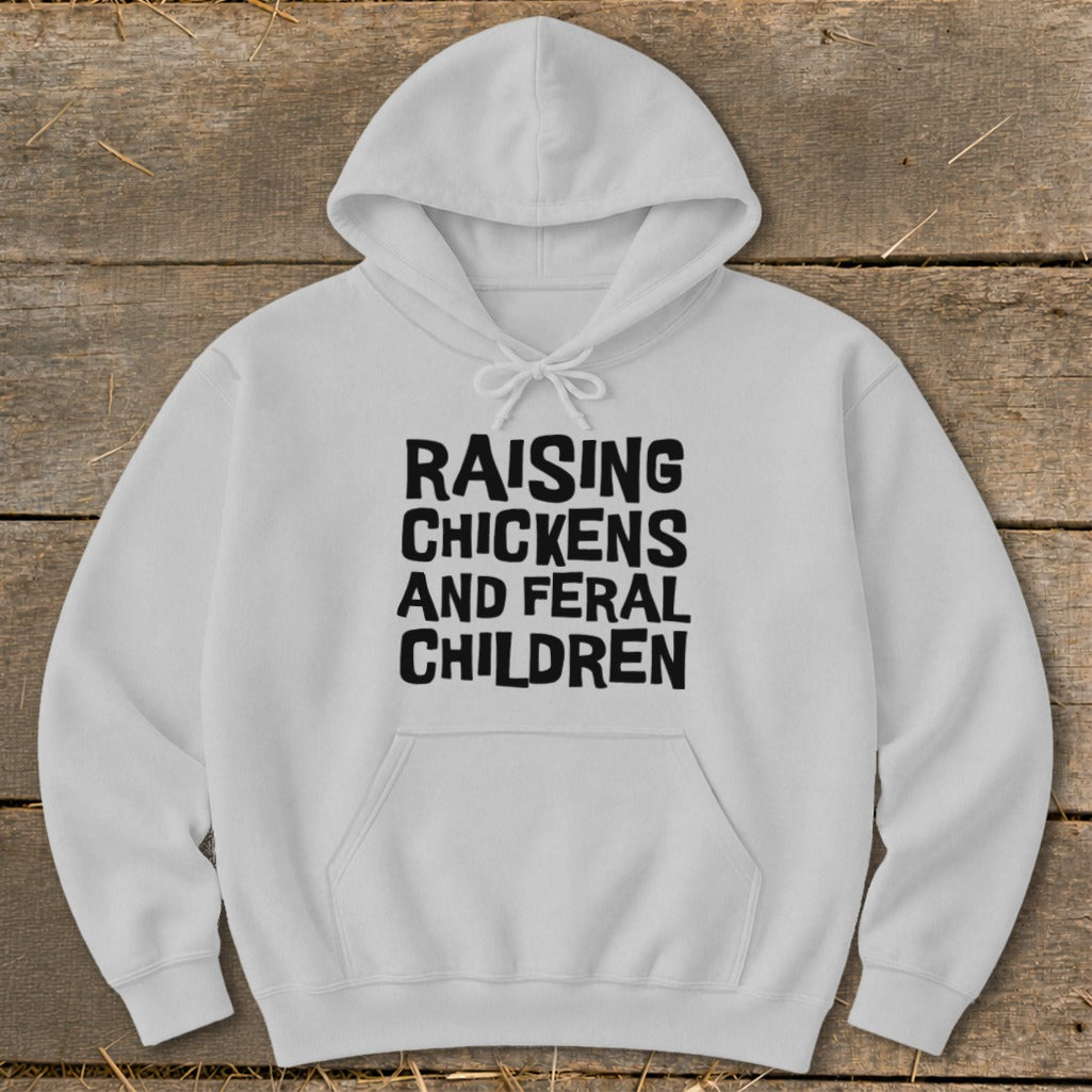 White hoodie with black text reading "RAISING CHICKENS AND FERAL CHILDREN".