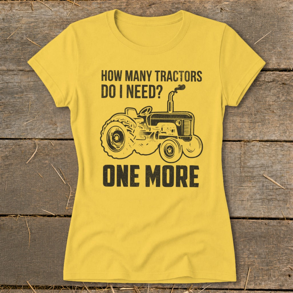 Yellow t-shirt with black graphic of tractor and text "How Many Tractors Do I Need? One More".