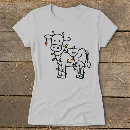 Light gray t-shirt with a black outline drawing of a cow wrapped in colorful Christmas lights.