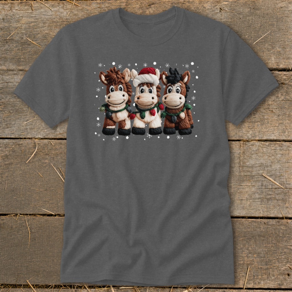 Three cartoon horses wear holiday decorations and stand together with snowflakes.
