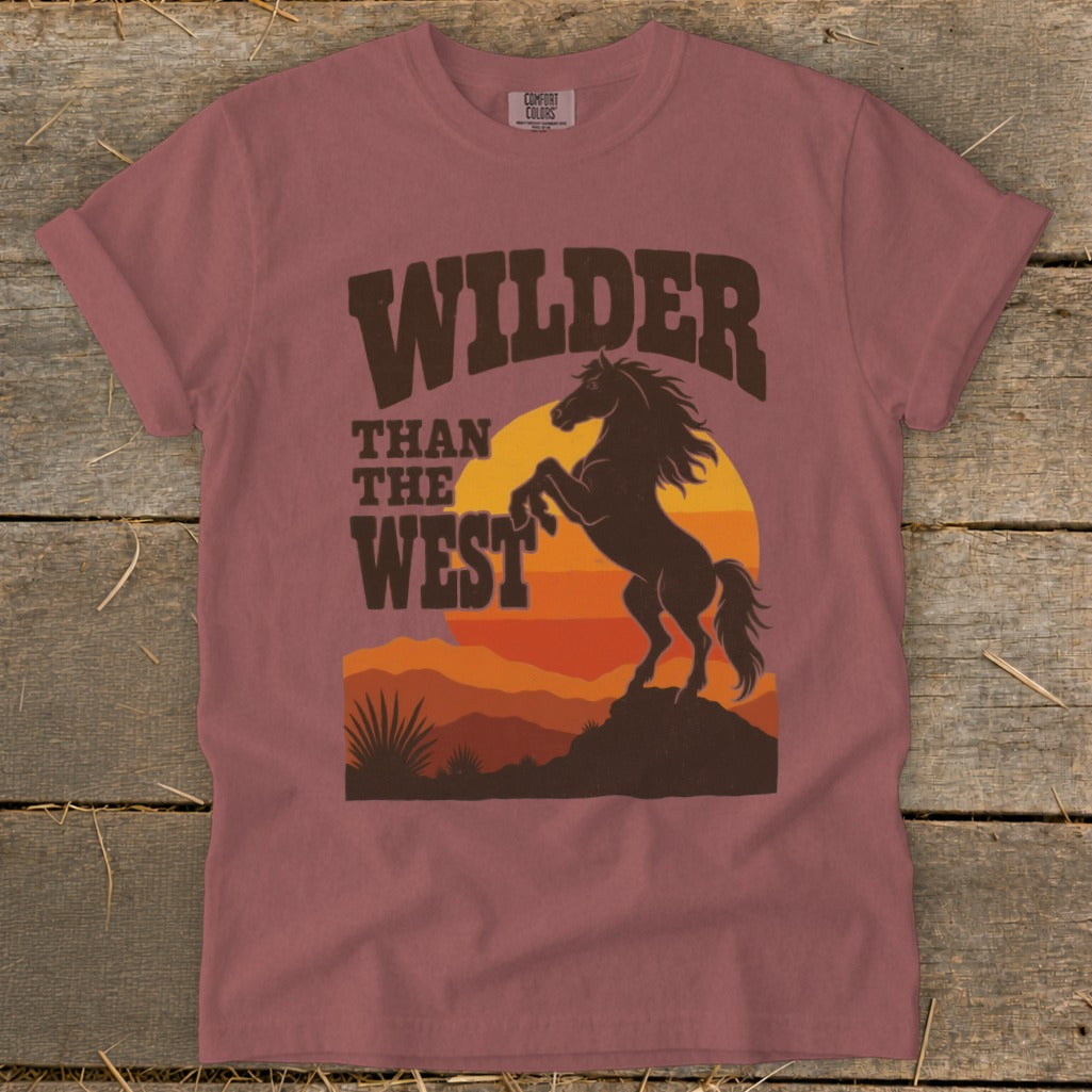 T-shirt with "Wilder Than The West" text and a rearing horse silhouette at sunset.