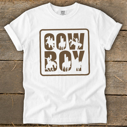 White t-shirt with "Cowboy" text and cowboy silhouettes in brown outline.