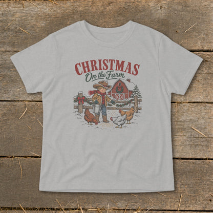 T-shirt with graphic of boy feeding chickens, barn, and text "Christmas On the Farm".