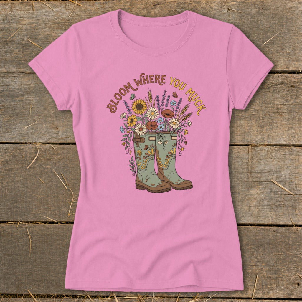 Pink t-shirt with boots overflowing with flowers and the text "Bloom Where You Muck."