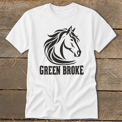 A white crewneck t-shirt featuring a black horse head graphic and the text GREEN BROKE on a rustic wooden background.