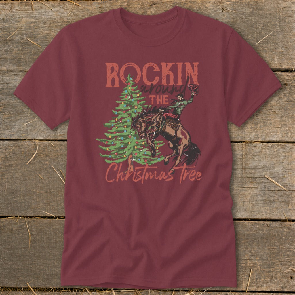 Maroon t-shirt with graphic of bronc rider, Christmas tree, and text "ROCKIN around THE Christmas Tree".