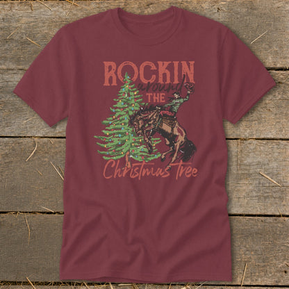 Maroon t-shirt with graphic of bronc rider, Christmas tree, and text "ROCKIN around THE Christmas Tree".