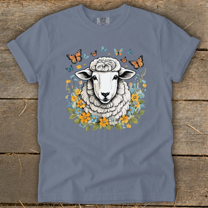 Sheep surrounded by butterflies and flowers on a grey t-shirt.