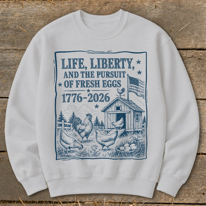 White sweatshirt with a blue graphic of chickens, coop, and American flag with text.