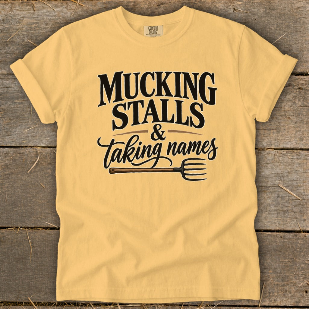 Yellow t-shirt with "MUCKING STALLS & taking names" and a pitchfork graphic.
