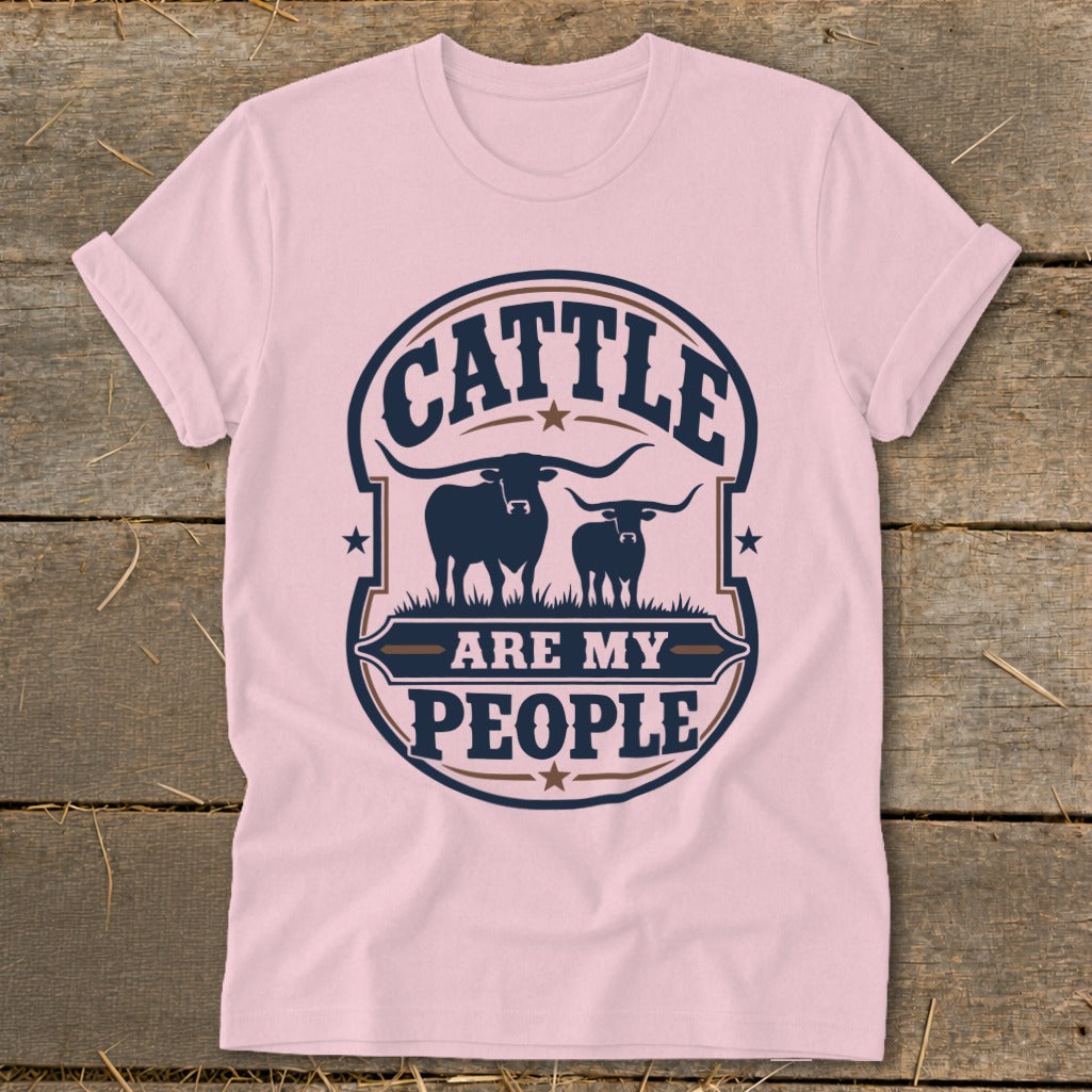 Pink t-shirt with a graphic reading "CATTLE ARE MY PEOPLE" above two longhorn cattle silhouettes.