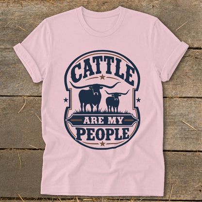 Pink t-shirt with a graphic reading "CATTLE ARE MY PEOPLE" above two longhorn cattle silhouettes.