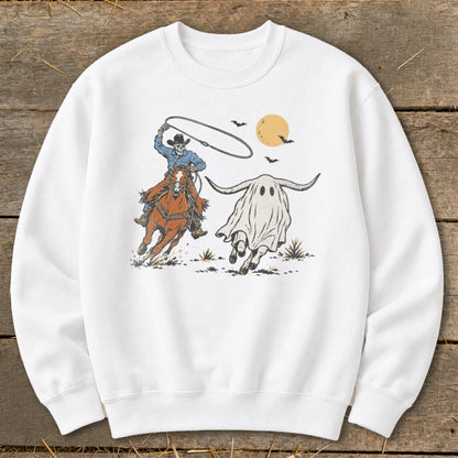 Skeleton cowboy on horseback chases a ghost longhorn with bats and moon.